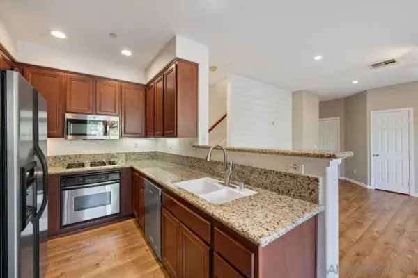 a kitchen with stainless steel appliances granite countertop a sink stove and refrigerator