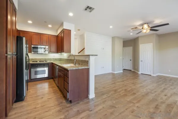 a kitchen with stainless steel appliances granite countertop a stove cabinets and entryway