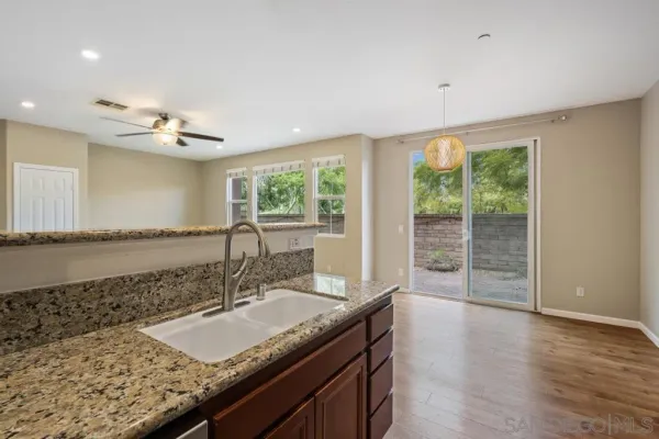 a bathroom with a granite countertop sink and a large mirror