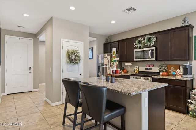 a kitchen with a table chairs refrigerator and cabinets