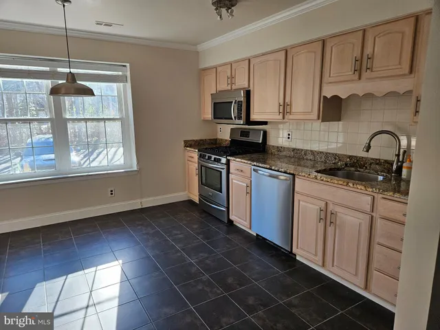a kitchen with granite countertop a refrigerator and a stove