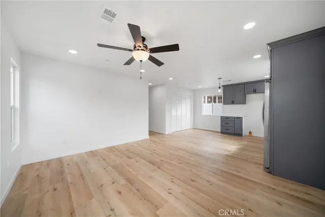 a view of empty room with kitchen and window