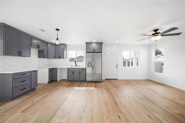 a large kitchen with cabinets wooden floor and stainless steel appliances