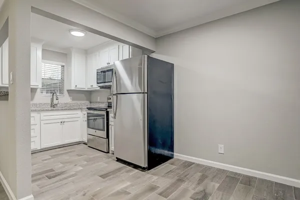 a kitchen with a refrigerator sink and white cabinets