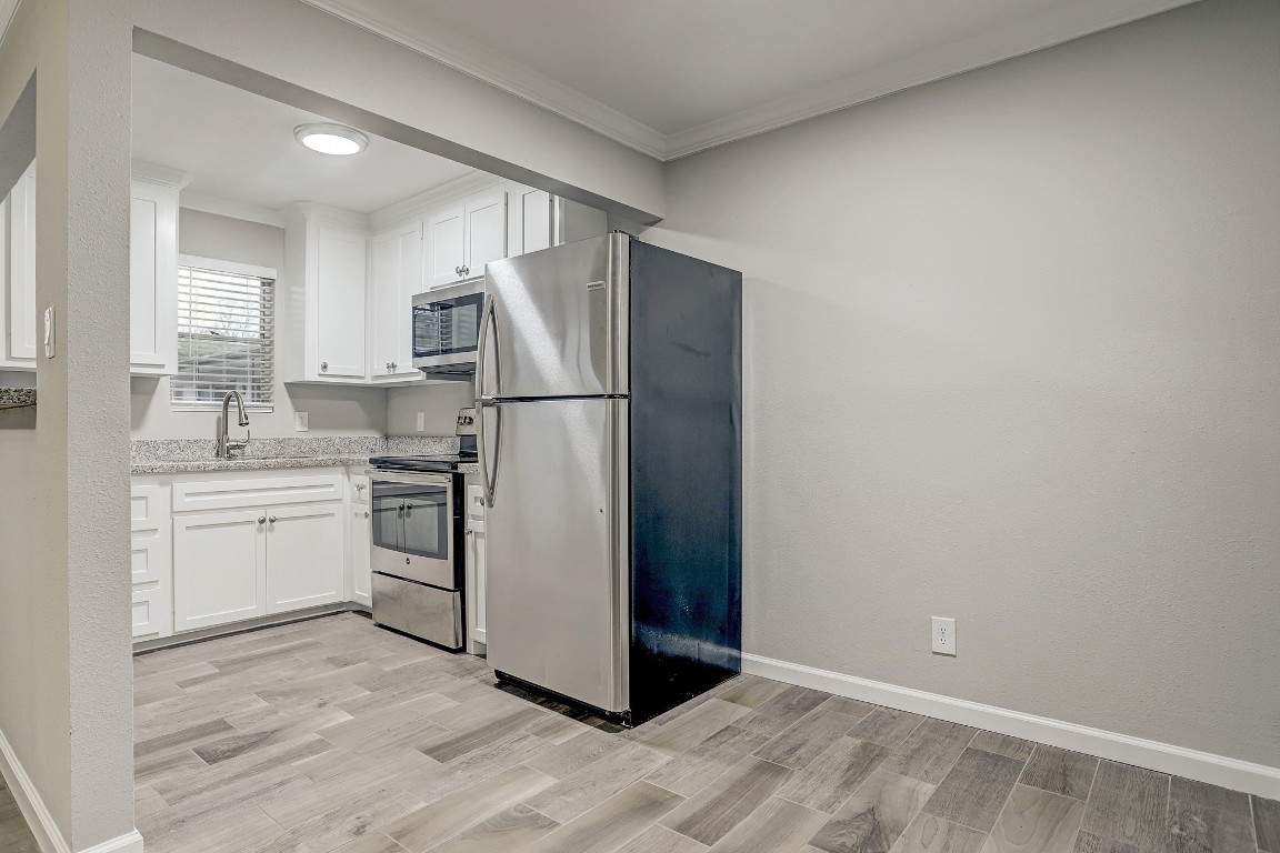 405 Hawthorne Street, Unit 22 Houston, TX 77006 - Photo 2 of 10 a kitchen with a refrigerator sink and white cabinets