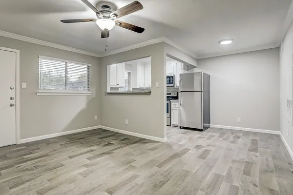 a view of empty room with wooden floor and ceiling fan