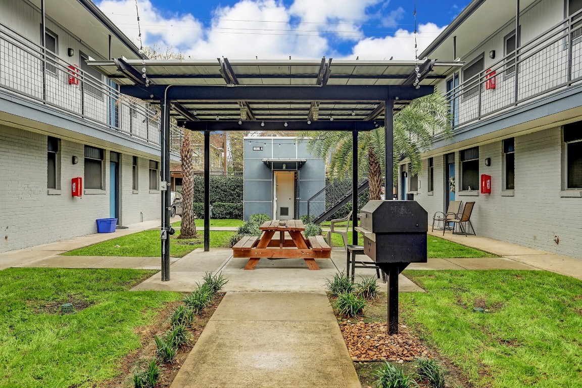 405 Hawthorne Street, Unit 22 Houston, TX 77006 - Photo 9 of 10 a patio with a table and chairs and a barbeque