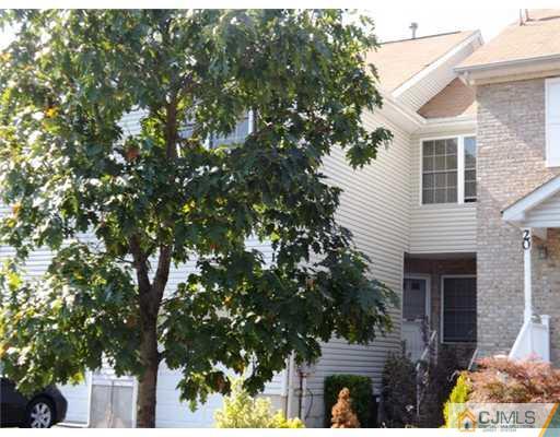 a front view of a house with a tree