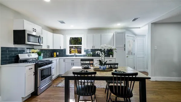 a kitchen with granite countertop white cabinets and black appliances