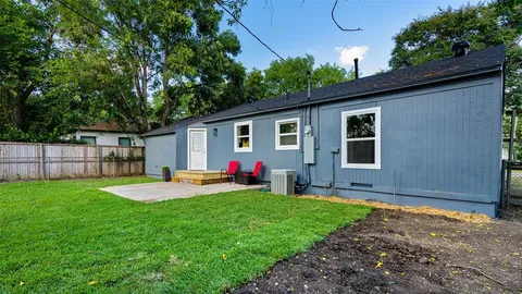 a view of a backyard with table and chairs and wooden fence