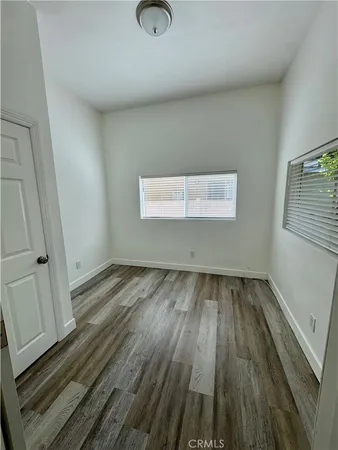 a view of a room with wooden floor and window