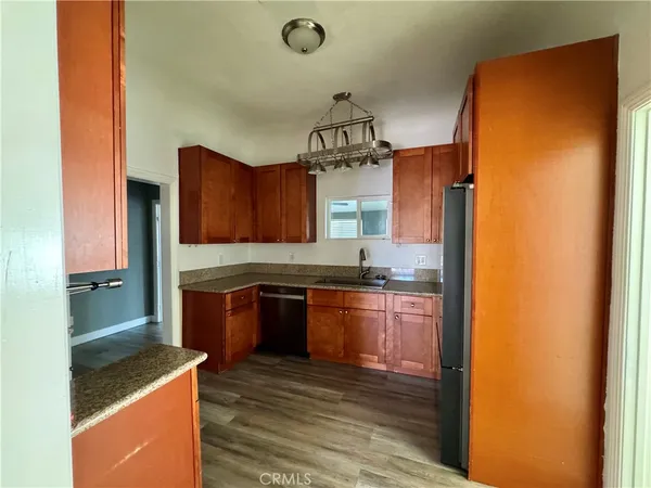 a kitchen with granite countertop a sink stove and refrigerator