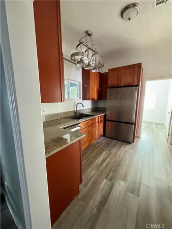 a kitchen with stainless steel appliances granite countertop a refrigerator a sink dishwasher a stove and a refrigerator