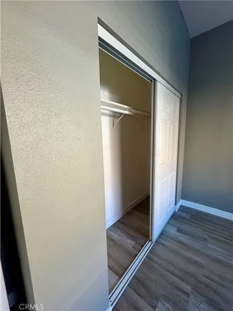 an empty room with wooden floor and closet
