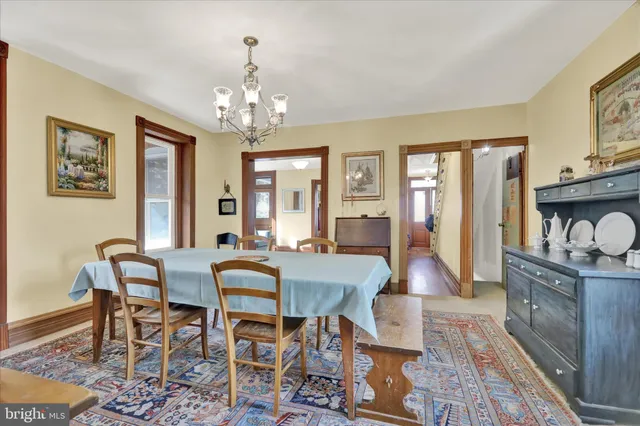 a view of a dining room with furniture a chandelier and wooden floor