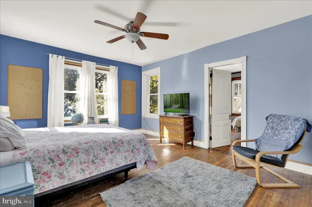 a bedroom with a bed a couch and a window