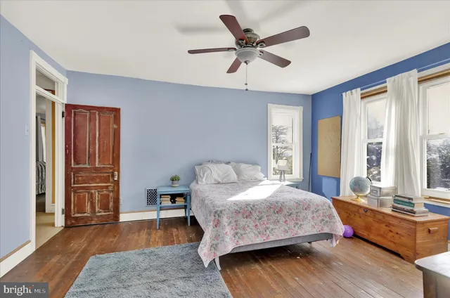 a bedroom with a bed and wooden floor