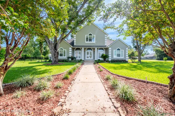 a front view of a house with a garden