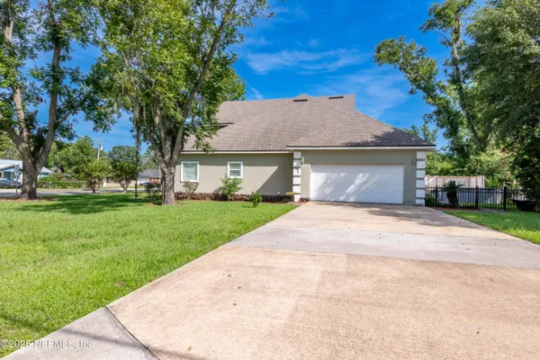 en empty room with chandelier fan and windows