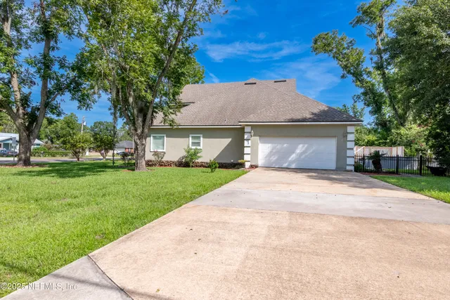 en empty room with chandelier fan and windows