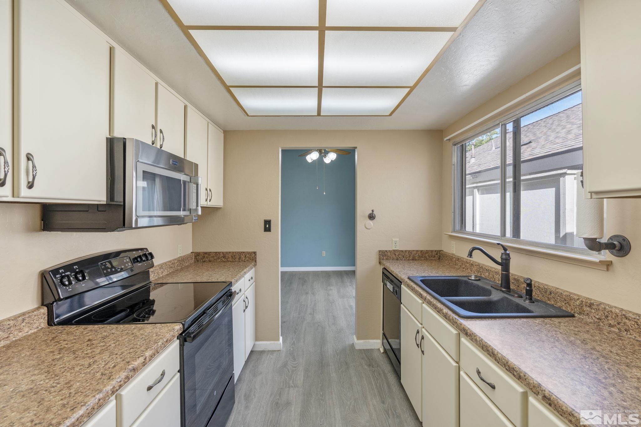 1235 Laredo Court Reno, NV 89503 - Photo 15 of 40 a kitchen with stainless steel appliances granite countertop a sink stove and cabinets