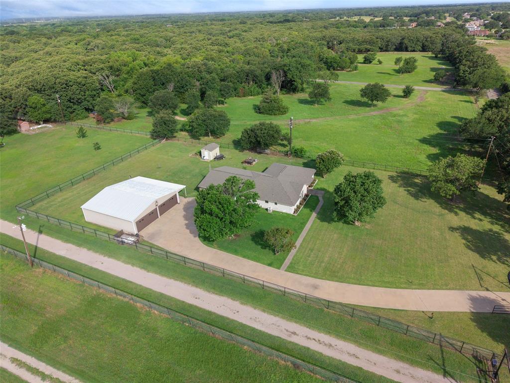 380 Farr Altom Road Seagoville, TX 75159 - Photo 30 of 30 Expansive property featuring a single-story residence, a large detached metal building with multiple garage doors, a gravel drive, and mature trees on a grassy lot