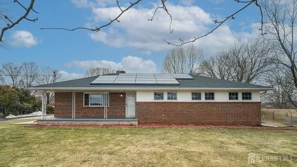 a front view of a house with a garden and yard