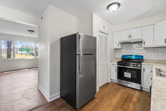 a kitchen with stainless steel appliances granite countertop a refrigerator and a stove