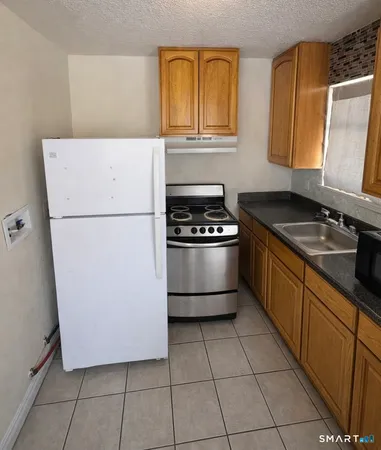 a kitchen with a stove a sink and a refrigerator