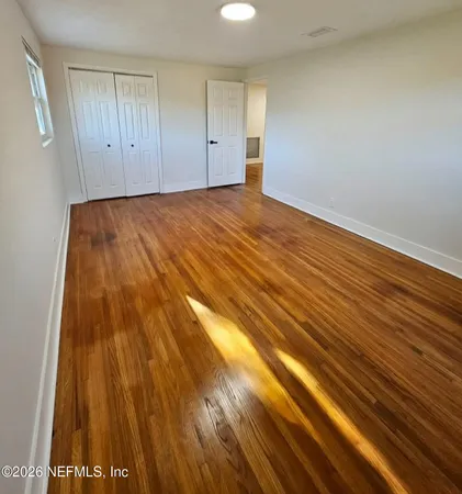 a view of an empty room with wooden floor