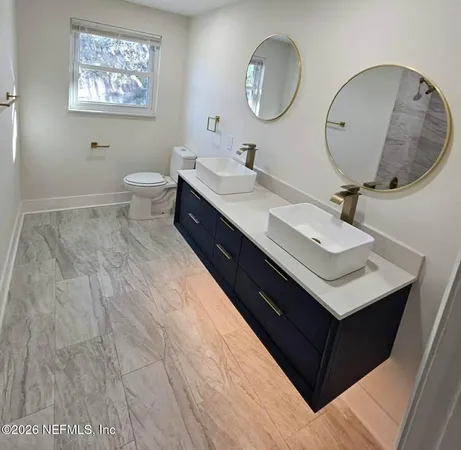 a en suite bathroom with a double vanity sink and a mirror