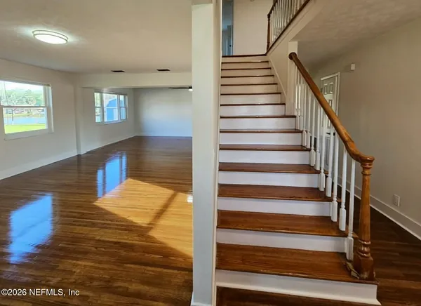 a view of entryway and hall with wooden floor