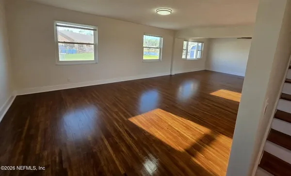 a view of wooden floor and windows in a room