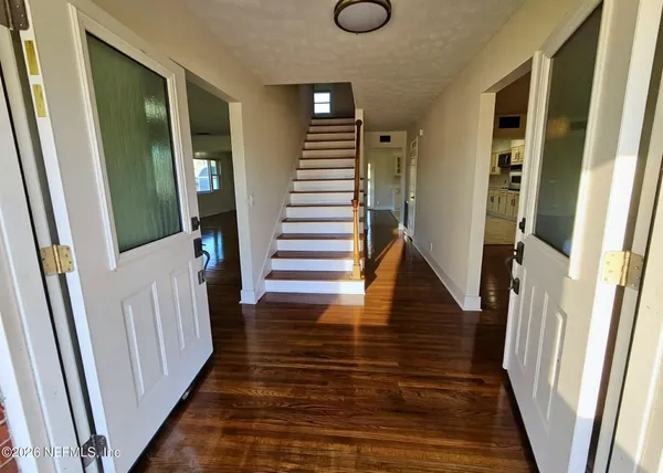 a view of entryway and hall with wooden floor