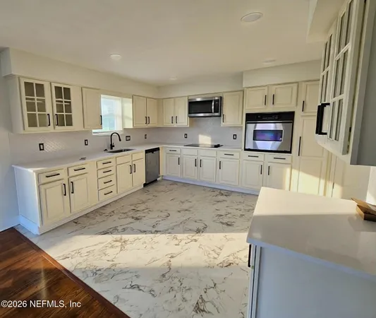 a large kitchen with stainless steel appliances kitchen island a cabinets and wooden floor