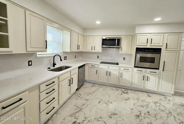 a kitchen with appliances cabinets and a sink