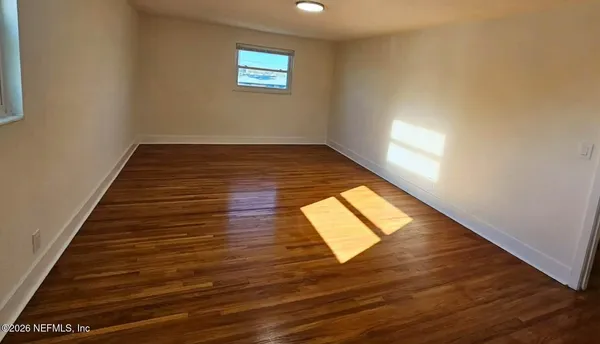 a view of wooden floor and windows in a room