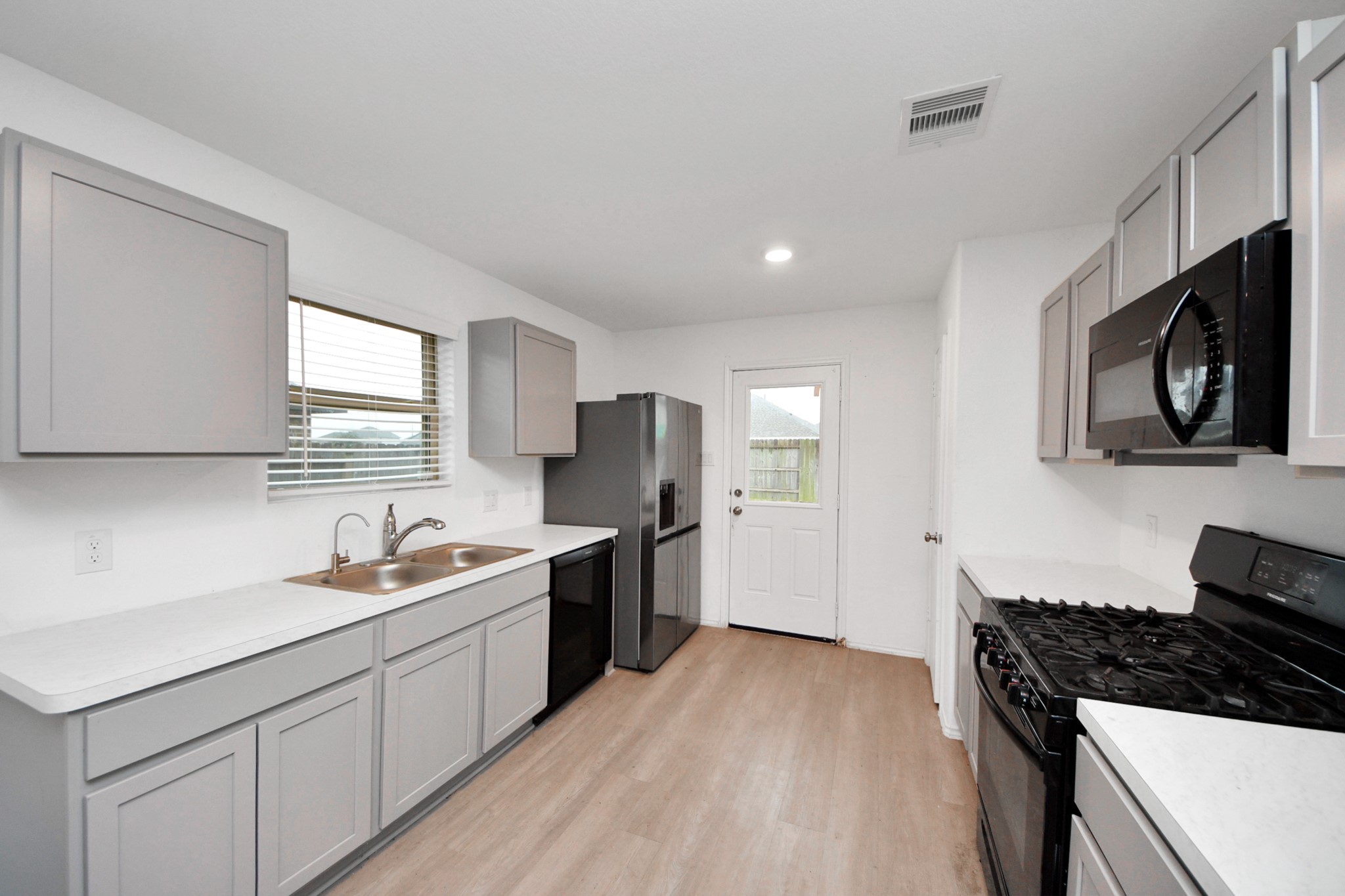 14606 Whitstone Gully Way Rosharon, TX 77583 - Photo 15 of 30 a kitchen with a sink stove top oven and refrigerator
