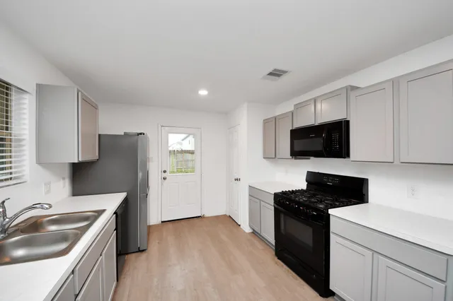 a kitchen with a sink stove and microwave