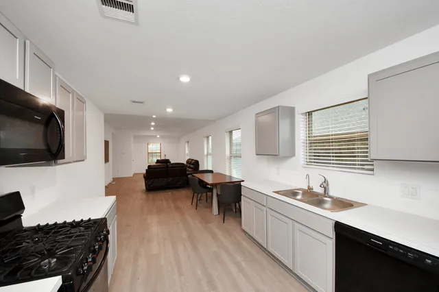 a kitchen with a sink and a stove top oven