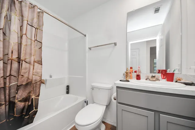 a bathroom with a sink toilet vanity tub and shower