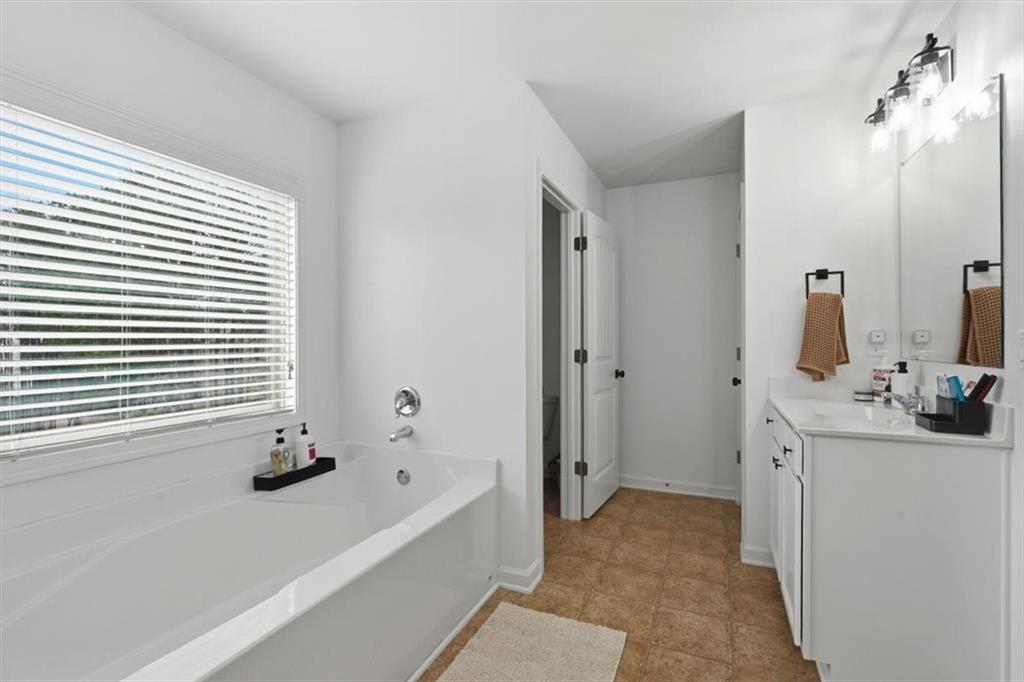 1675 Cedar Mill Drive Powder Springs, GA 30127 - Photo 28 of 45 a bathroom with a bathtub sink and mirror