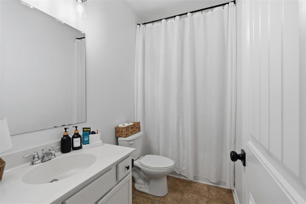 1675 Cedar Mill Drive Powder Springs, GA 30127 - Photo 39 of 45 a bathroom with a sink a toilet and shower curtain