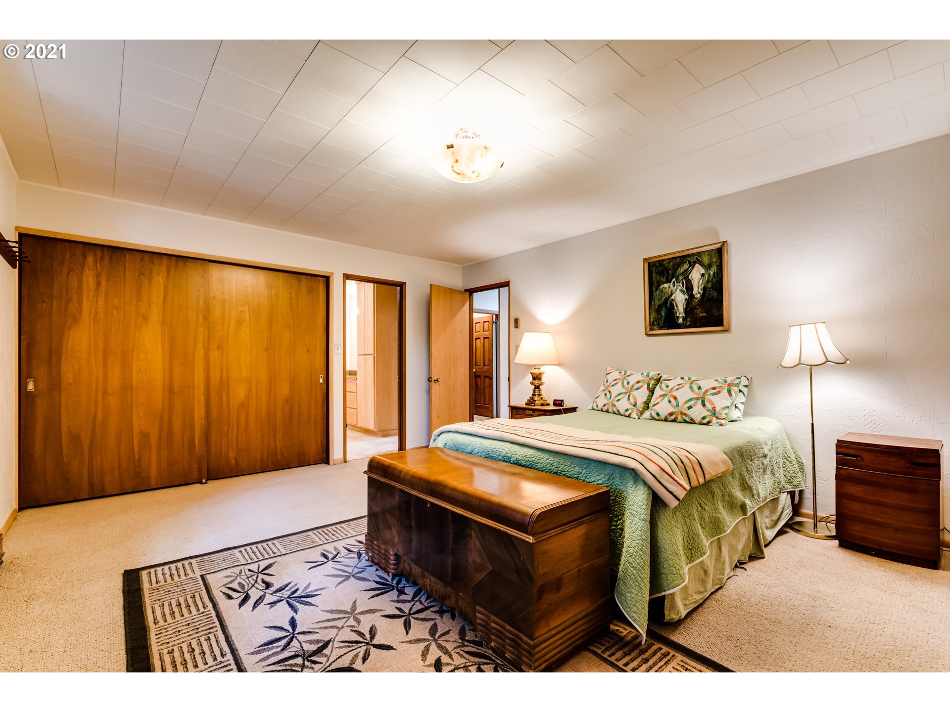 79385 Sears Road Cottage Grove, OR 97424 - Photo 15 of 32 a spacious bedroom with a bed a lamp and a large window