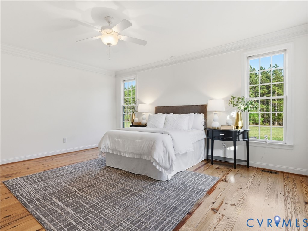 2880 Millmount Parkway Powhatan, VA 23139 - Photo 17 of 36 a bedroom with a bed and a table with wooden floor