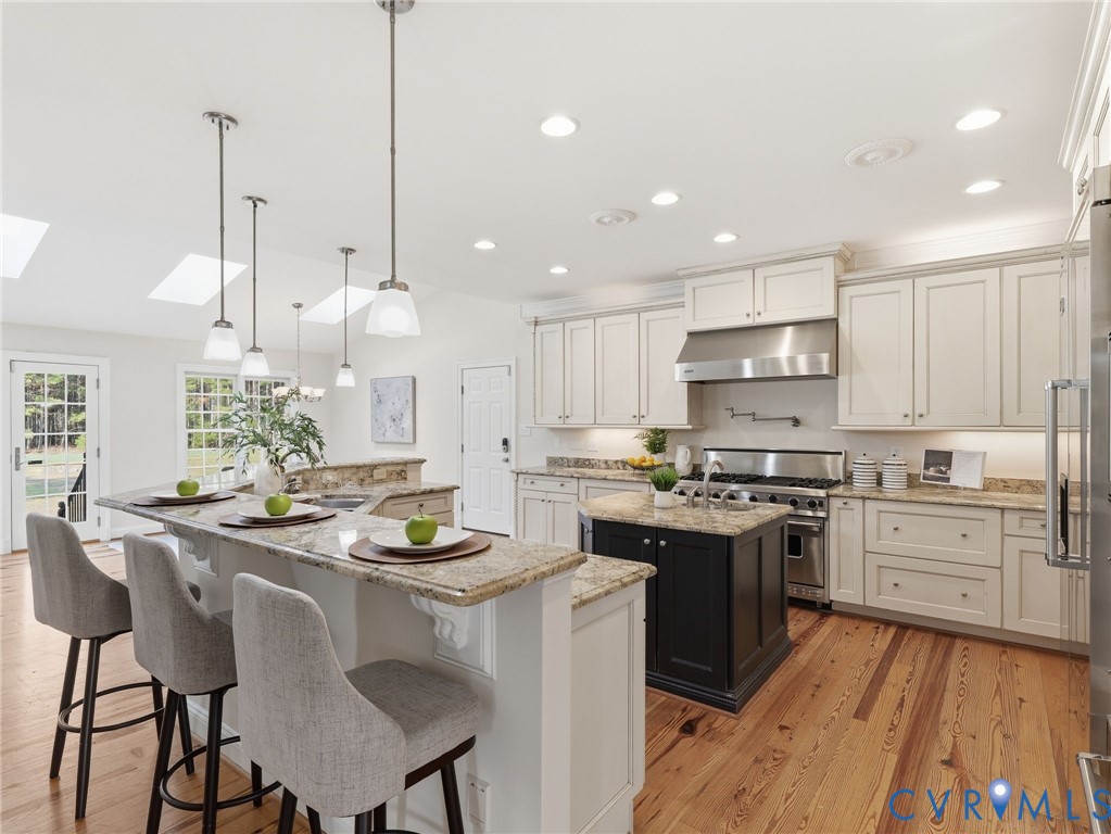 2880 Millmount Parkway Powhatan, VA 23139 - Photo 3 of 36 a kitchen with kitchen island granite countertop a sink a stove a dining table and chairs