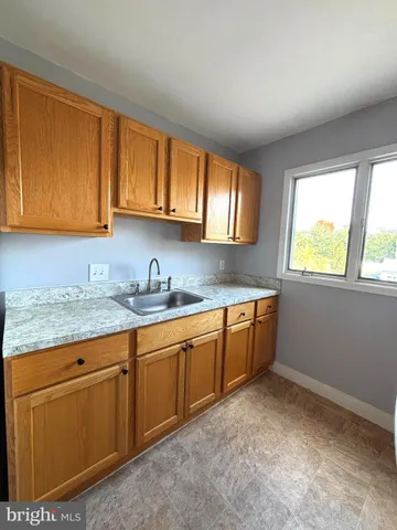 a kitchen with granite countertop a sink cabinets and window