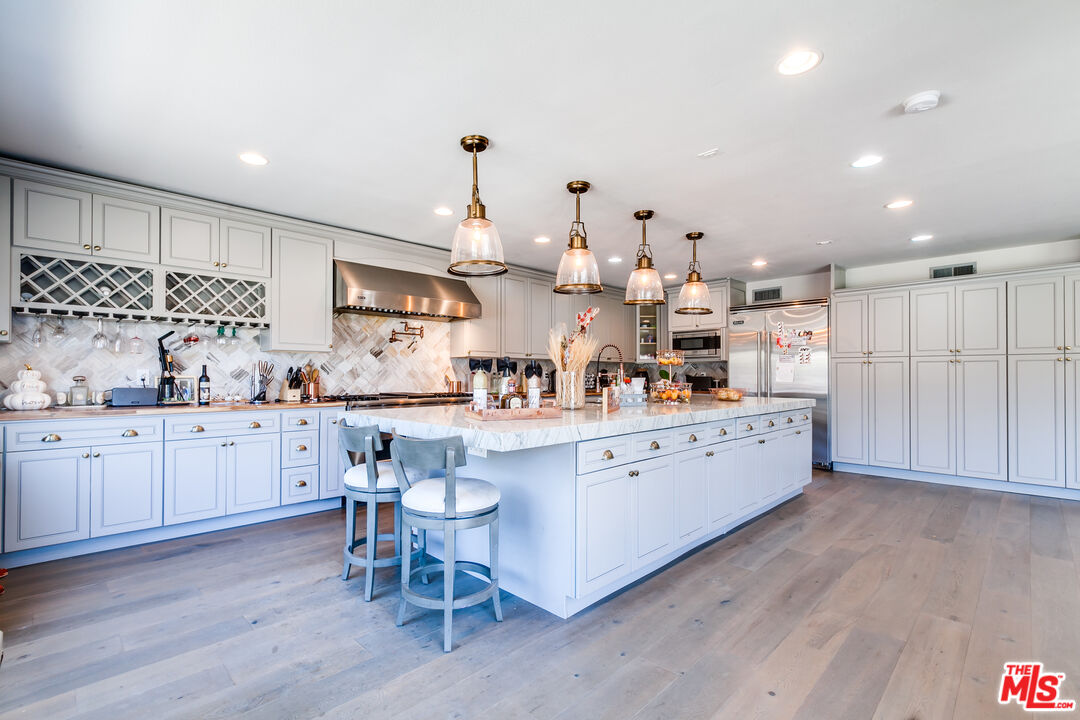 17153 Rayen Street Northridge, CA 91325 - Photo 11 of 47 a kitchen with stainless steel appliances kitchen island granite countertop a sink and cabinets