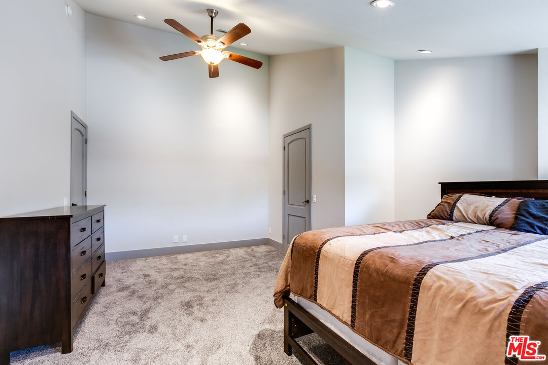 17153 Rayen Street Northridge, CA 91325 - Photo 23 of 47 a bedroom with a bed and a chandelier