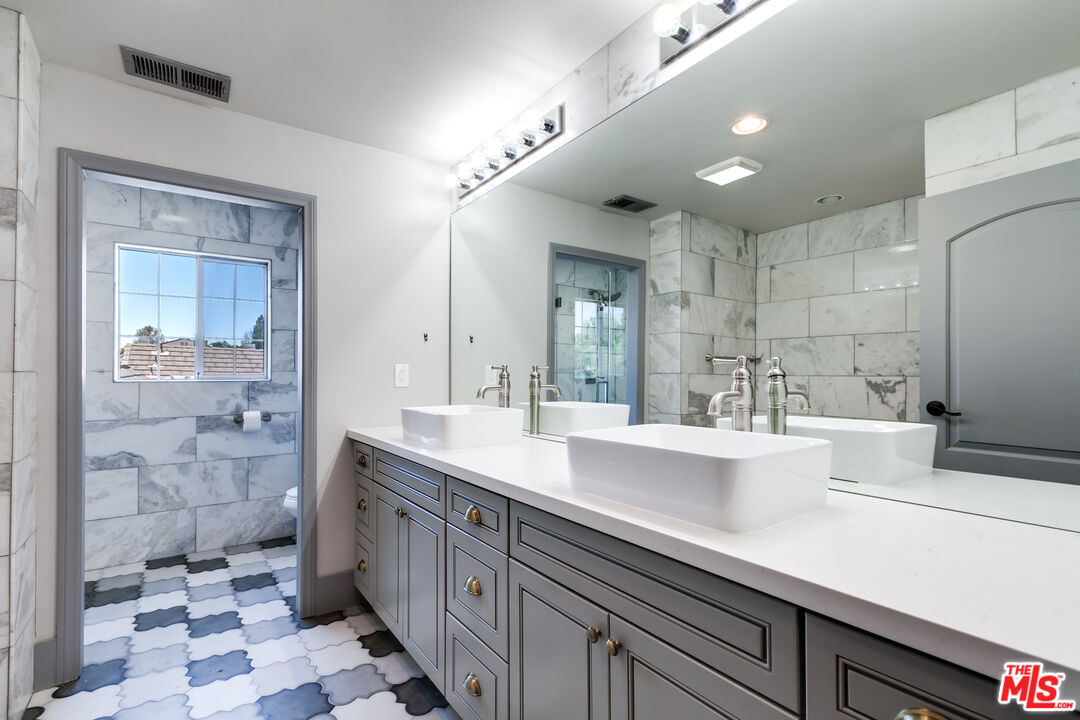17153 Rayen Street Northridge, CA 91325 - Photo 25 of 47 a view of a double vanity sink and a mirror